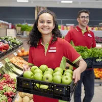 Eine PENNY Mitarbeiterin und ein Mitarbeiter befüllen die Obst und Gemüse Abteilung im Markt